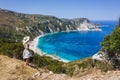 A tourist woman wearing hat enjoying beautiful Petani beach on Kefalonia Ionian island, Greece, during her summer