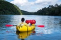 Tourist on yellow packraft rubber boat with red padle