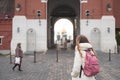 Tourist young girl in autumn jacket with backpack looking at Kremlin gates standing on Red Square with old woman in headscarf