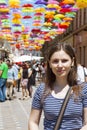 Tourist young woman on a street decorated with colored and open umbrellas Royalty Free Stock Photo