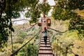 Tourist on zip line elevated wooden bridge over tropical forest