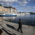 Touristic boats/hotel buildings/blue skies/people walking, Stockholm.