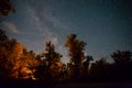 Touristic camp fire in a night forest under starry sky with milky way Royalty Free Stock Photo