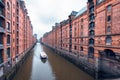Touristic cruise boat on a channel with bridges in the warehouse district Speicherstadt in Hamburg, Germany Royalty Free Stock Photo