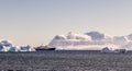Touristic cruise liner among blue icebergs close to Cuverville Island