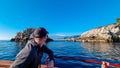 Touristic man on boat with panoramic view from open sea on snow capped volcano Mount Etna in Taormina, Sicily, Italy, Europe, EU. Royalty Free Stock Photo