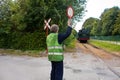 Touristic railway flagman at level crossing stopping car traffic