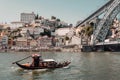 Touristic riverboat sailing past riverside and huge bridge over river Douro Royalty Free Stock Photo