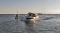 Touristic ship sails in Venice lagoon at sunset, Italy.