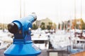 Touristic telescope look at the city with view of Barcelona Spain, close up old blue binoculars on background viewpoint the pier