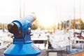 Touristic telescope look at the city with view of Barcelona Spain, close up old blue binoculars on background viewpoint the pier