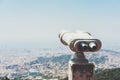 Touristic telescope look at the city with view of Barcelona Spain, close up old metal binoculars on background viewpoint overlook