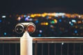 Touristic telescope look at city with view of Barcelona Spain, close up old metal binoculars on background viewpoint, hipster coin