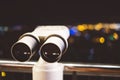 Touristic telescope look at city with view of Barcelona Spain, close up old metal binoculars on background viewpoint, hipster coin