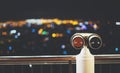 Touristic telescope look at city with view of Barcelona Spain, close up old metal binoculars on background viewpoint, hipster coin