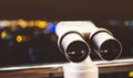 Touristic telescope look at city with view of Barcelona Spain, close up old metal binoculars on background viewpoint, hipster coin