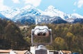 Touristic telescope look at the city with view snow mountains, closeup binocular on background viewpoint observe vision, metal Royalty Free Stock Photo