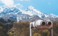 Touristic telescope look at the city with view snow mountains, closeup binocular on background viewpoint observe vision, metal Royalty Free Stock Photo