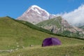 touristic tent in front of spectacular view of magnificent kazbek mountain with snow peak in caucasus in geogria. Royalty Free Stock Photo