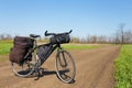 Touristic travel bicycle with bags on a ground road