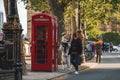 Tourists admiring iconic red telephone booth on streets of Westminster city Royalty Free Stock Photo