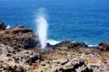 Tourists admiring the Nakalele blowhole on the Maui coastline. A jet of water and air is violently forced out through the hole in