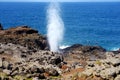 Tourists admiring the Nakalele blowhole on the Maui coastline. A jet of water and air is violently forced out through the hole in