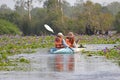 Tourists adventure through water lilies in a kayak
