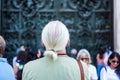 Tourists appreciating the beautiful bas-reliefs on the bronze door of building of the Milan Cathedral Duomo di Milano, the