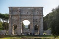 Tourists at the Arch of Constantine. Triumphal arch and Colosseum in the background in Rome, Italy in 2023