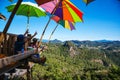 Tourists asian couple sitting eat noodle on the wooden platform and looking scenic view of beautiful nature mountains at Ban Jabo,
