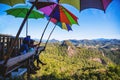 Tourists asian couple sitting eat noodle on the wooden platform and looking scenic view of beautiful nature mountains at Ban Jabo,