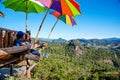 Tourists asian couple sitting eat noodle on the wooden platform and looking scenic view of beautiful nature mountains at Ban Jabo,