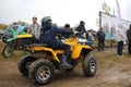 tourists on ATVs and all-terrain vehicles ride on a dirty road to the race