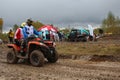 tourists on ATVs and all-terrain vehicles ride on a dirty road to the race