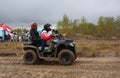 tourists on ATVs and all-terrain vehicles ride on a dirty road to the race