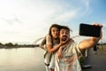 Tourists backpacker couple, Happy young travelers enjoying vacation together on sunset in new city. Stylish man and woman in Royalty Free Stock Photo
