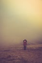 Tourists with backpacks climb to the top of the mountain in fog. Royalty Free Stock Photo