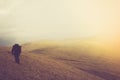 Tourists with backpacks climb to the top of the mountain in fog. Royalty Free Stock Photo