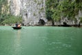 Tourists on bamboo boats touring around the islands and caves of ha long bay