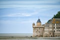 Tourists on the beach and one of the towers of the wall of Mont Saint Michel, France Royalty Free Stock Photo