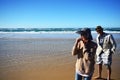 Tourists on beach tasting pipi shellfish at Fraser Island