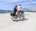 Tourists on a bicycle tandem ride along the waterfront.