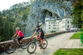 Tourists on a bike tour at Predjama Castle in Slovenia