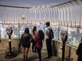 Tourists and Binoculars on top of Empire State Building at Night