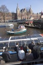 Tourists board canal boat near Amsterdam central station