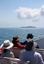 Tourists on a boat on a cruise looking at an island in a distance on the way to the Great Keppel Island in the Capricorn area in