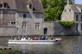 Tourists on a boat during a cruise on the water channels of the city near Beguinage, Bruges, Belgium Royalty Free Stock Photo