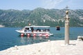 Tourists on a boat docking on the island of Lady of the rock