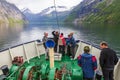 Tourists in the bow of a ship on its way into Geiranger in Norway Royalty Free Stock Photo